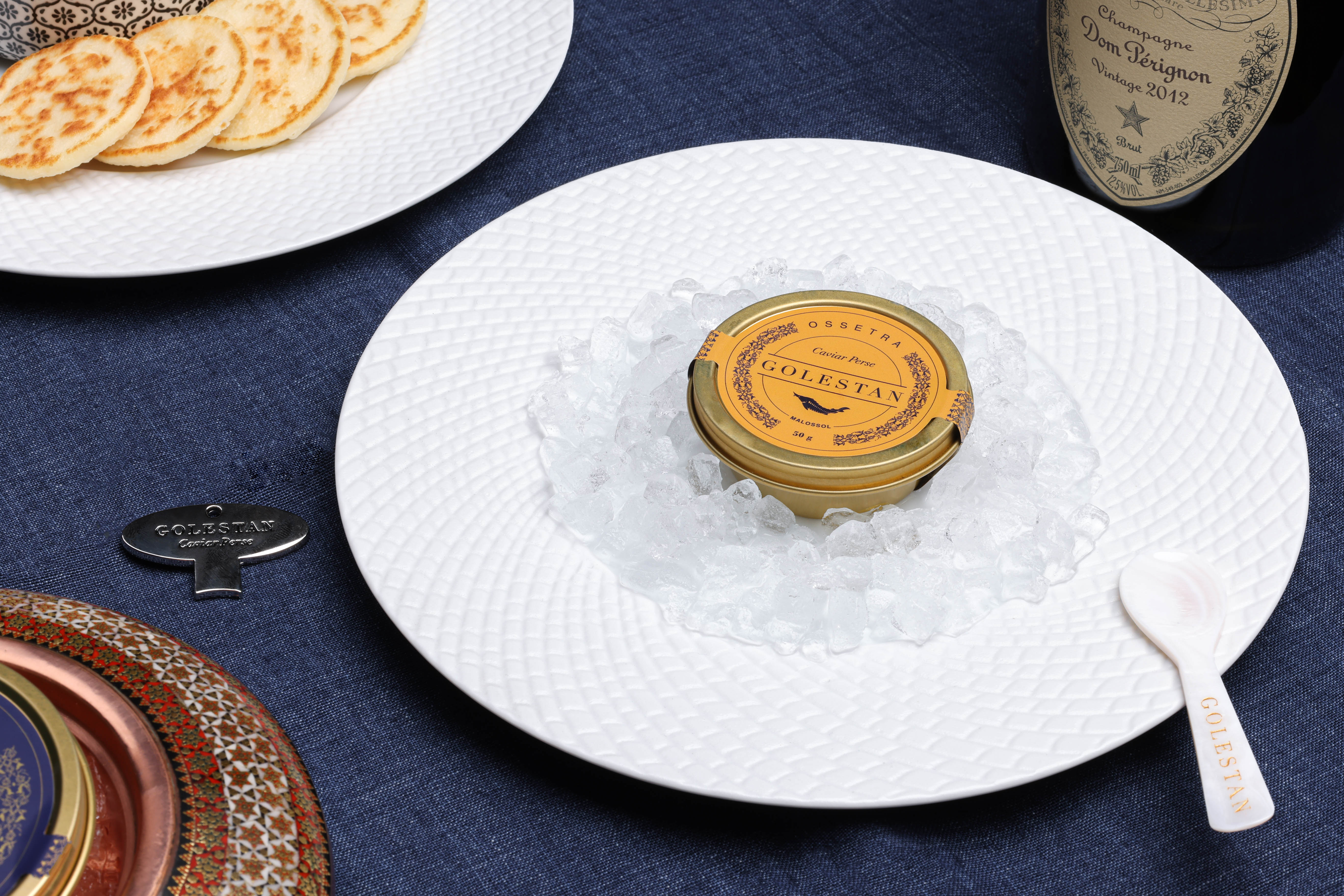 caviar ossetra fermé sur assiette et entouré de glaçons avec blinis et champagne Golestan Caviar